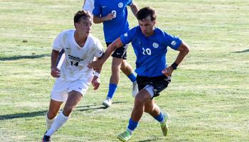 Liam McLean playing soccer at UIS in white Prairie Stars jersey