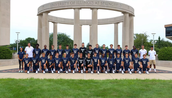 Team photo of UIS mens soccer team in blue uniforms, along with staff