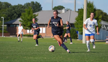 Mallory Herber playing soccer in blue UIS uniform