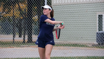 Maria Garcia Gama playing tennis in blue UIS uniform