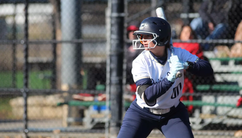 Olivia DeLuca batting in white UIS uniform