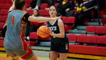 Brynn Tabeling playing basketball in blue UIS uniform
