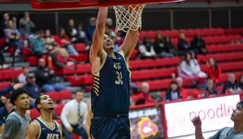 Alex Stell dunking a basketball at UMSL