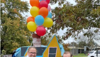 family dressed like the characters from Disney's "Up" in front of their decorated car