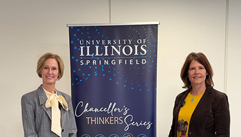 Two women standing beside a University of Illinois Springfield banner.