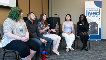 Panel discussion with five seated people in a conference room.