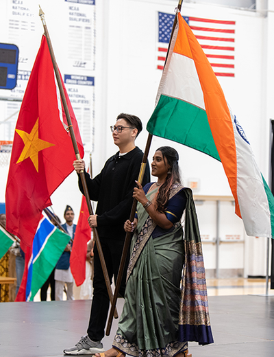 Students holding flags on stage