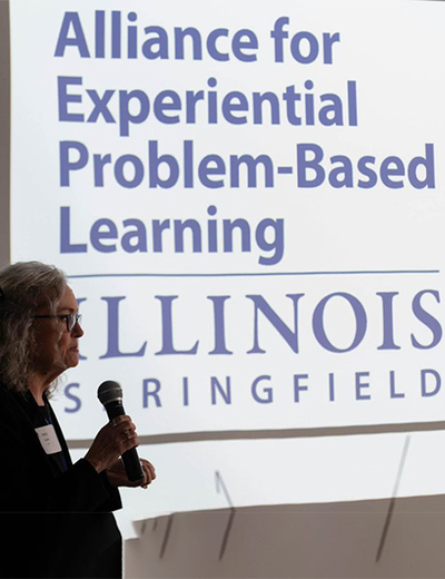 Alliance for Experiential Problem-Based Learning logo on a screen with Betsy Goulet talking