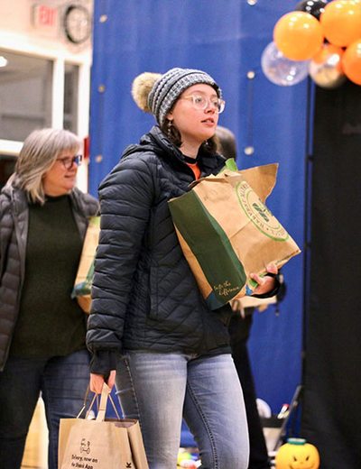 Student holding bags of food