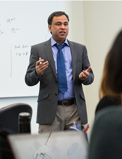 UIS professor Mohammed Mohi Uddin teaching a class using hand gestures in a classroom. 