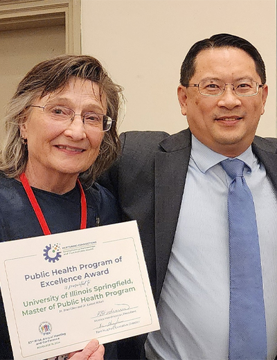 Lenore Killam and Brian Chen hold a Public Health Program of Excellence Award from the Illinois Public Health Association.