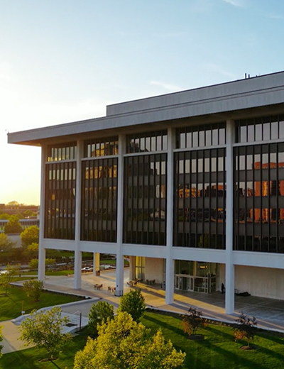 Horace Mann building in downtown Springfield at sunset, with trees and sidewalks in the foreground.