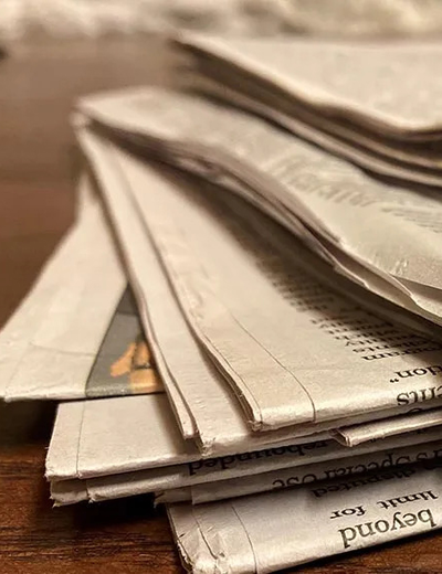 A stack of newspapers on a desk.