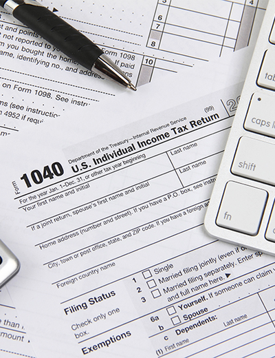 1040 tax form with a pen and computer keyboard.