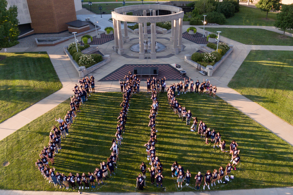 Students form the letters "UIS" in front of the Colonnade.