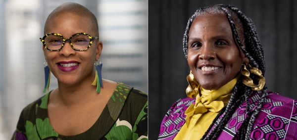 Two women smiling, one with glasses, bright earrings, and the other in a patterned outfit.
