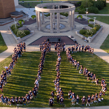 Students form the letters "UIS" in front of the Colonnade.