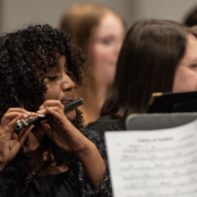 Musicians playing instruments in an orchestra setting.