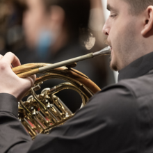Musician playing a French horn.