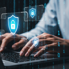 Hands typing on a laptop with digital security icons.