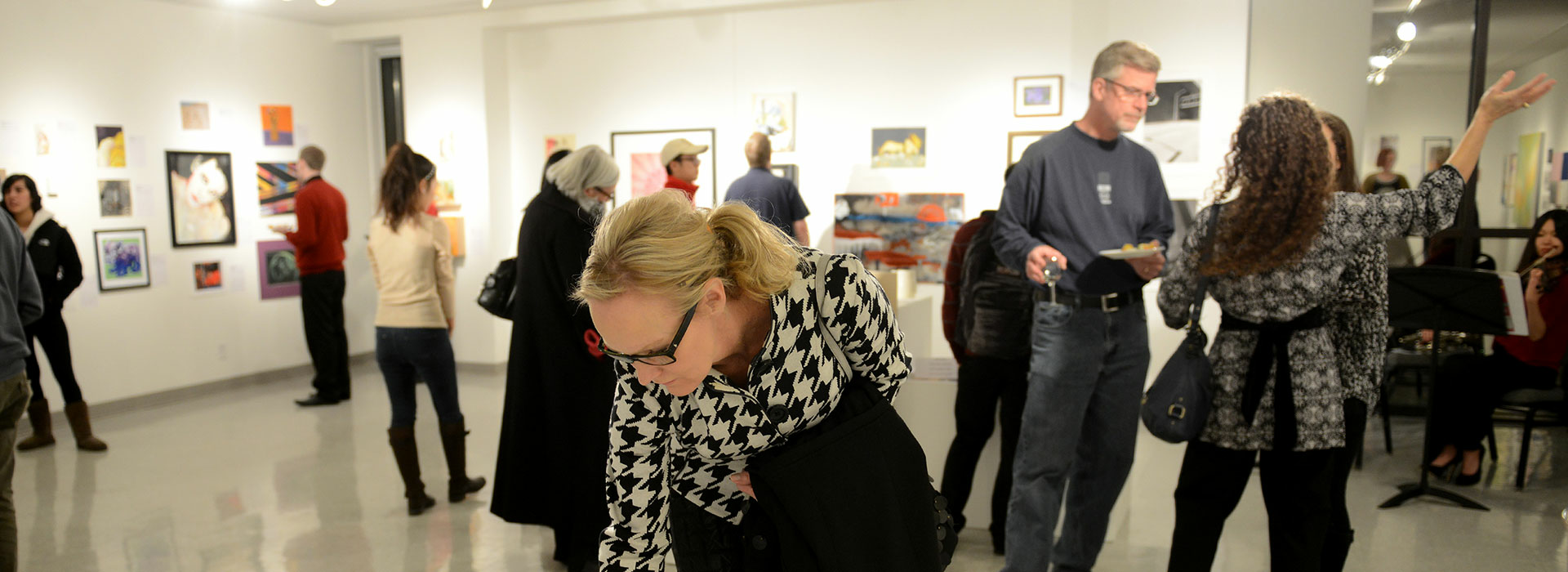 Crowd of people looking at items to bid on at UIS Visual Arts Gallery auction