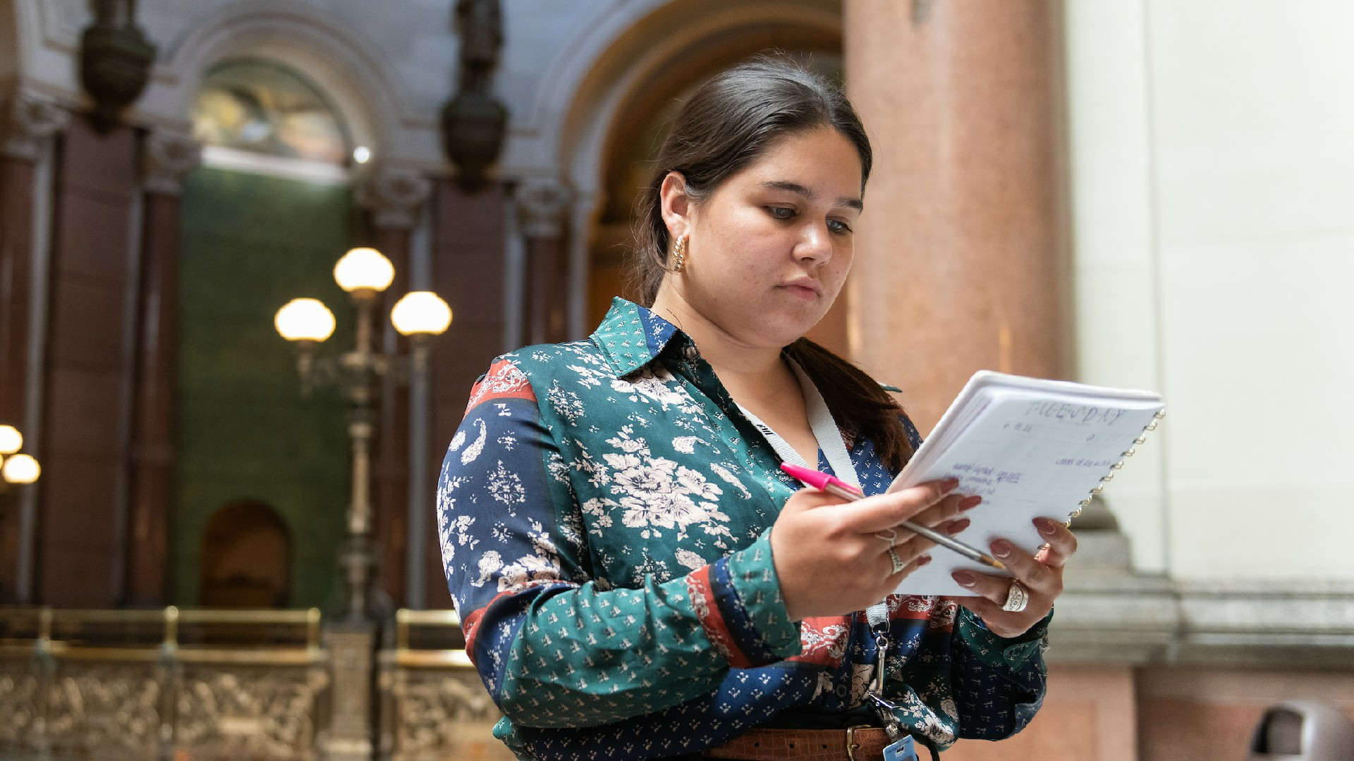 Reporter checking notes in Statehouse hallway