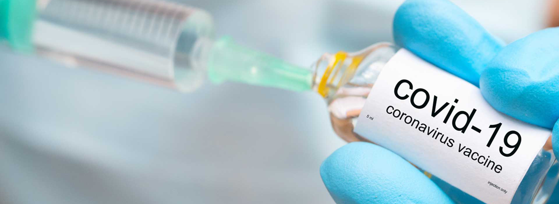 syringe getting vaccine from bottle