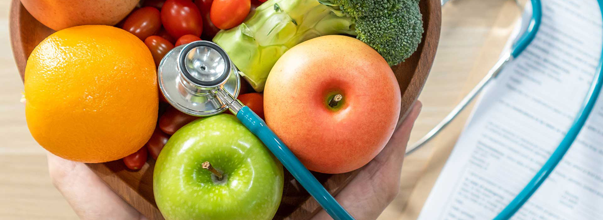 Stethoscope in bowl of fruit and vegetables