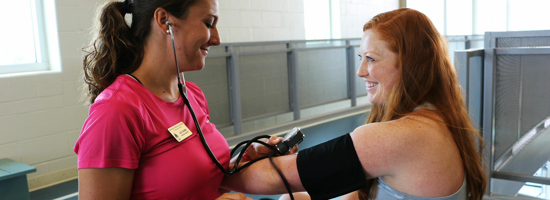 student taking someone's blood pressure