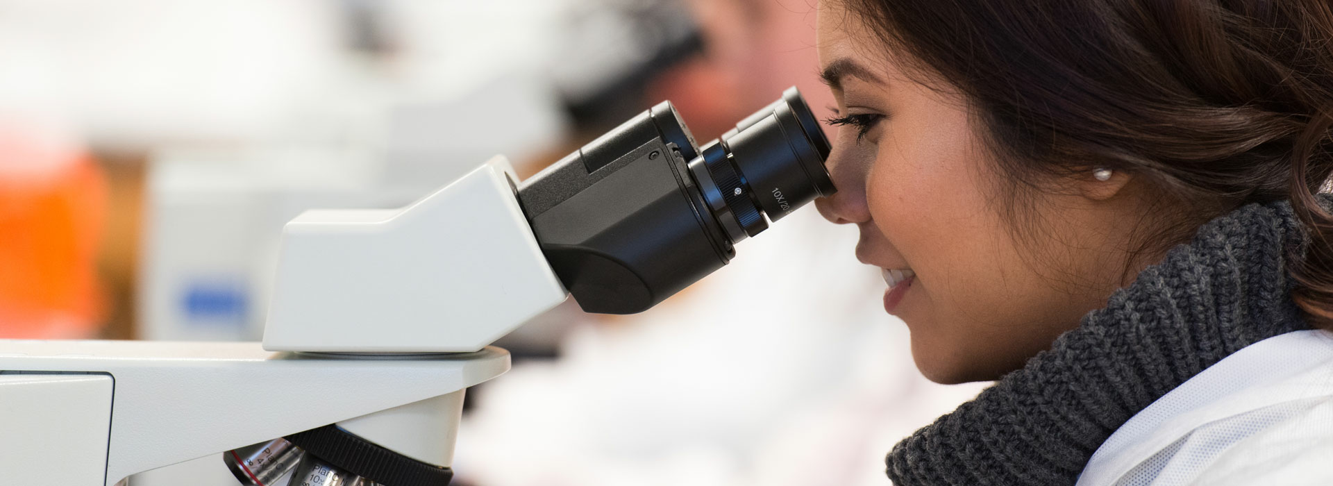 student looking through microscope