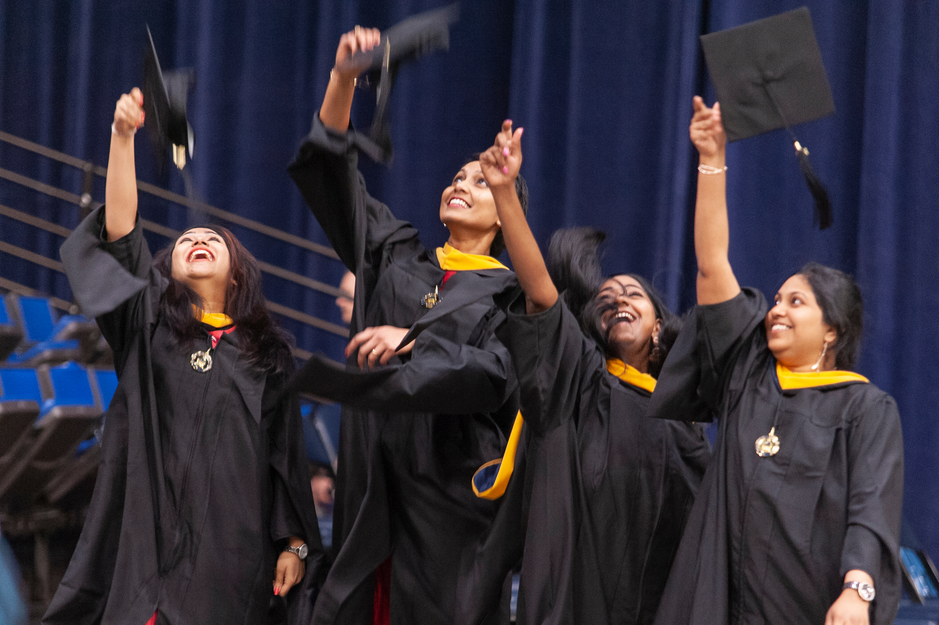 A group of students throw their caps in the air at a graduation ceremony