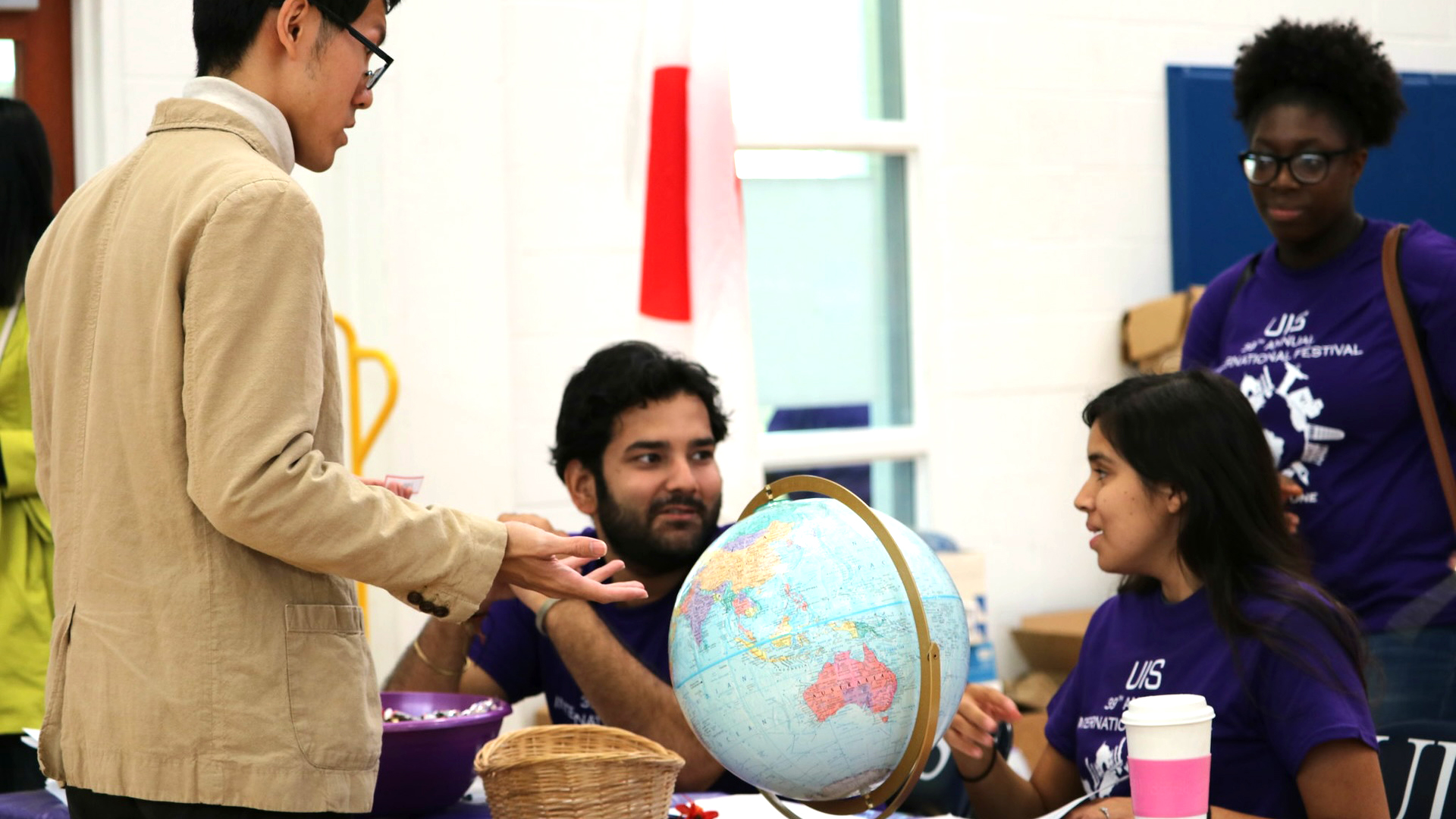 students talking at a table with a globe