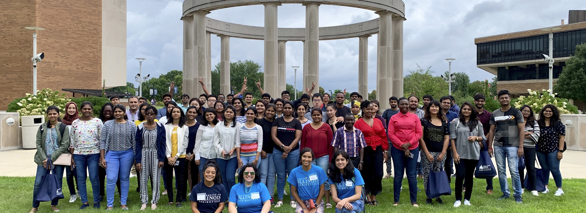 group photo of many international students posing in front of the colonnade
