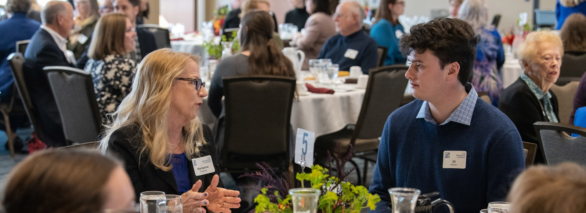 Several people sit around a table and share stories during a lunch