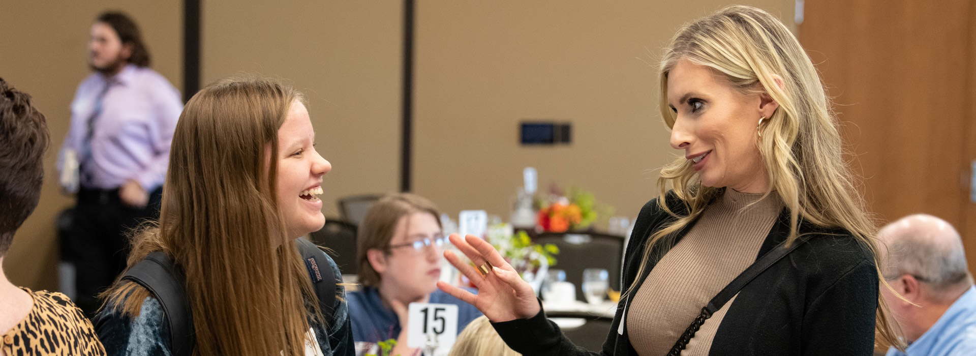 a student and an alum talking at a scholarship luncheon