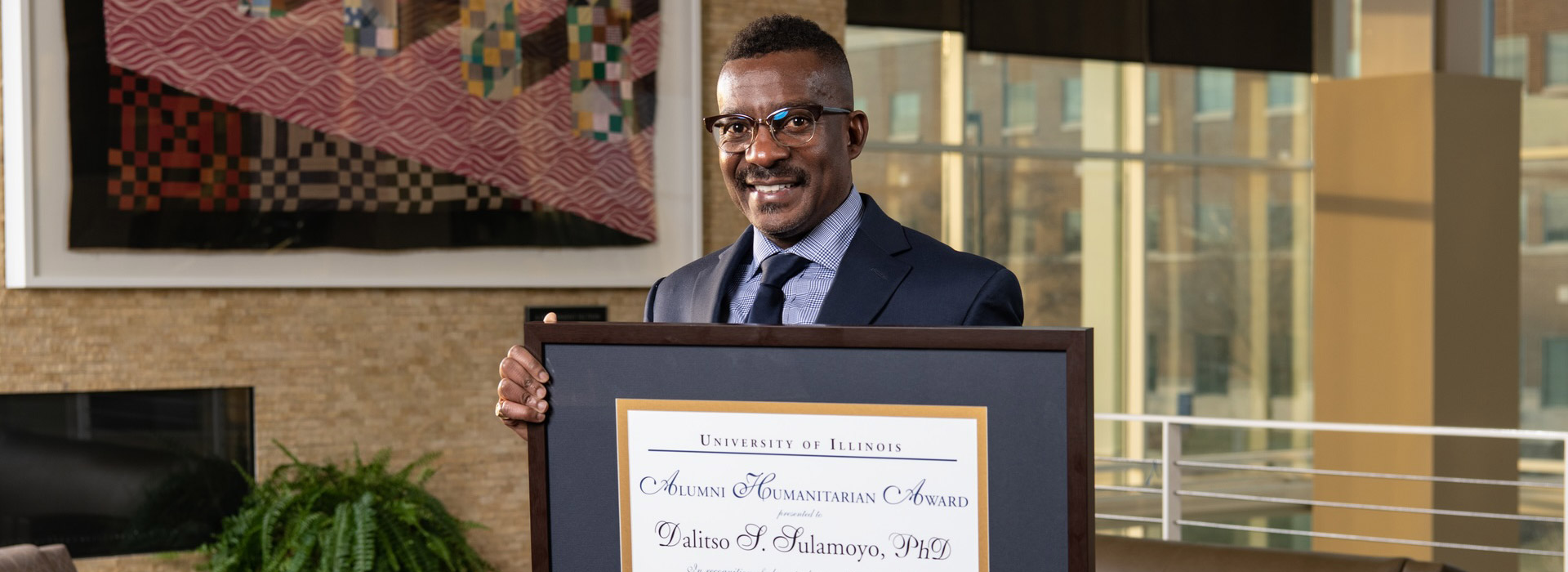 Dalitso Tulamoyo posing with his award plaque