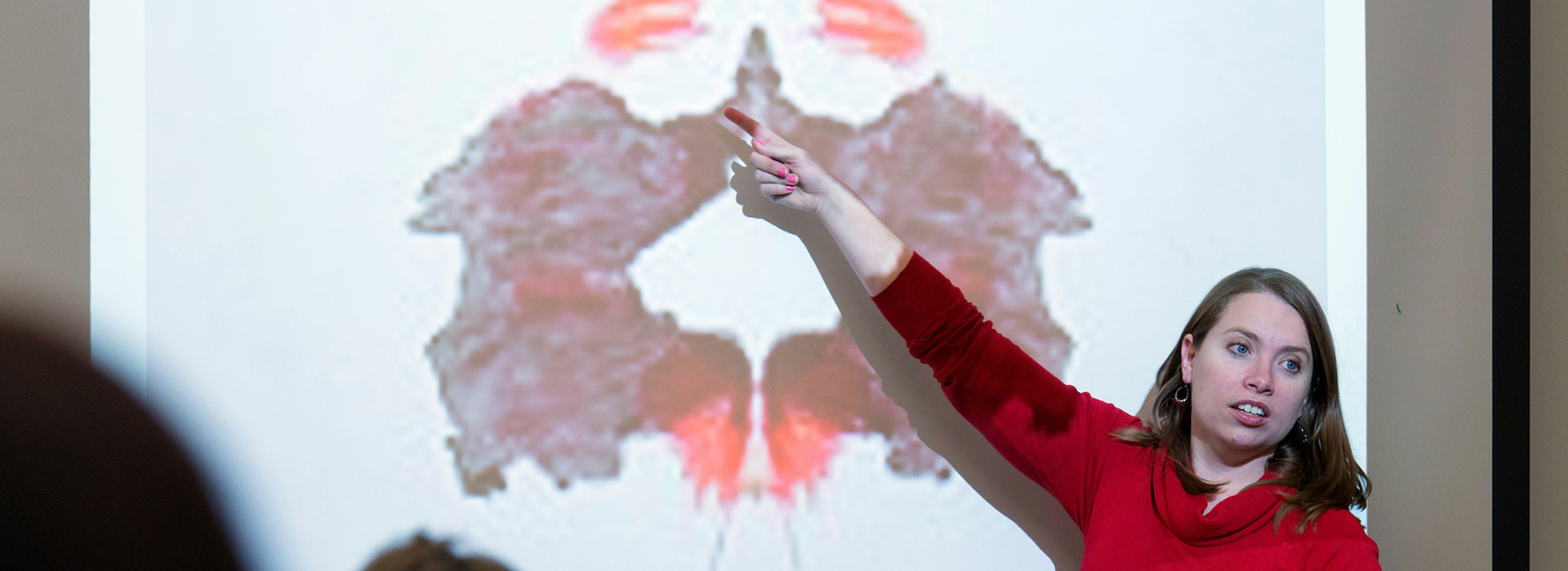 psychology professor pointing to a Rorschach test on an overhead projector