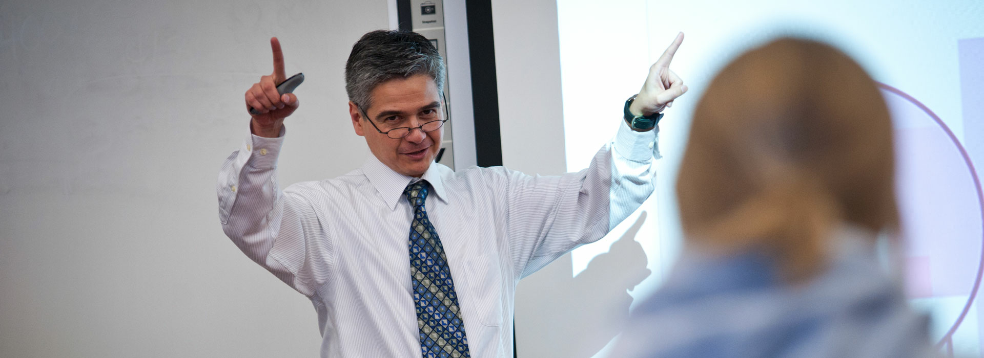 a male teacher teaching at the front of the classroom