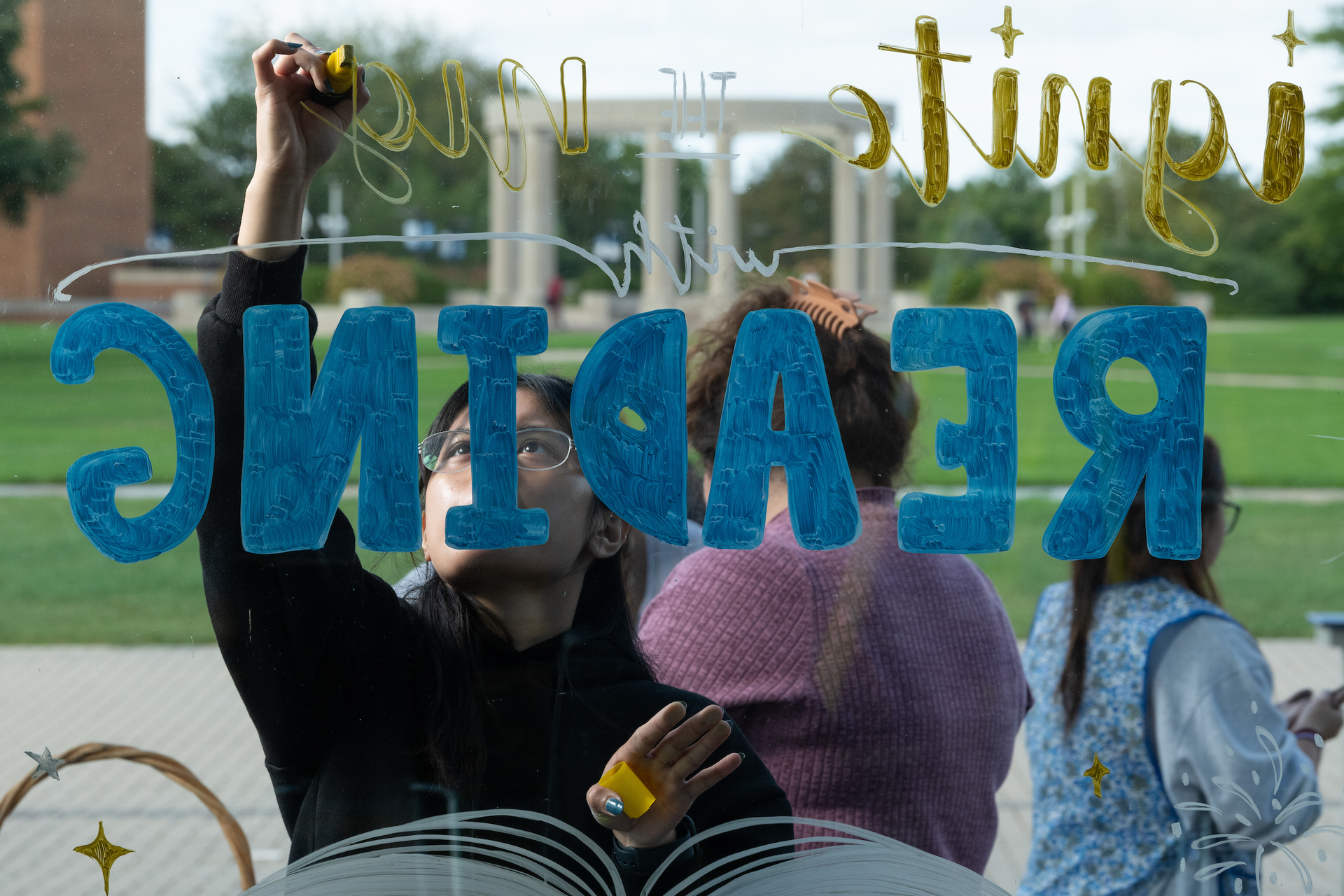 Student writing on glass window