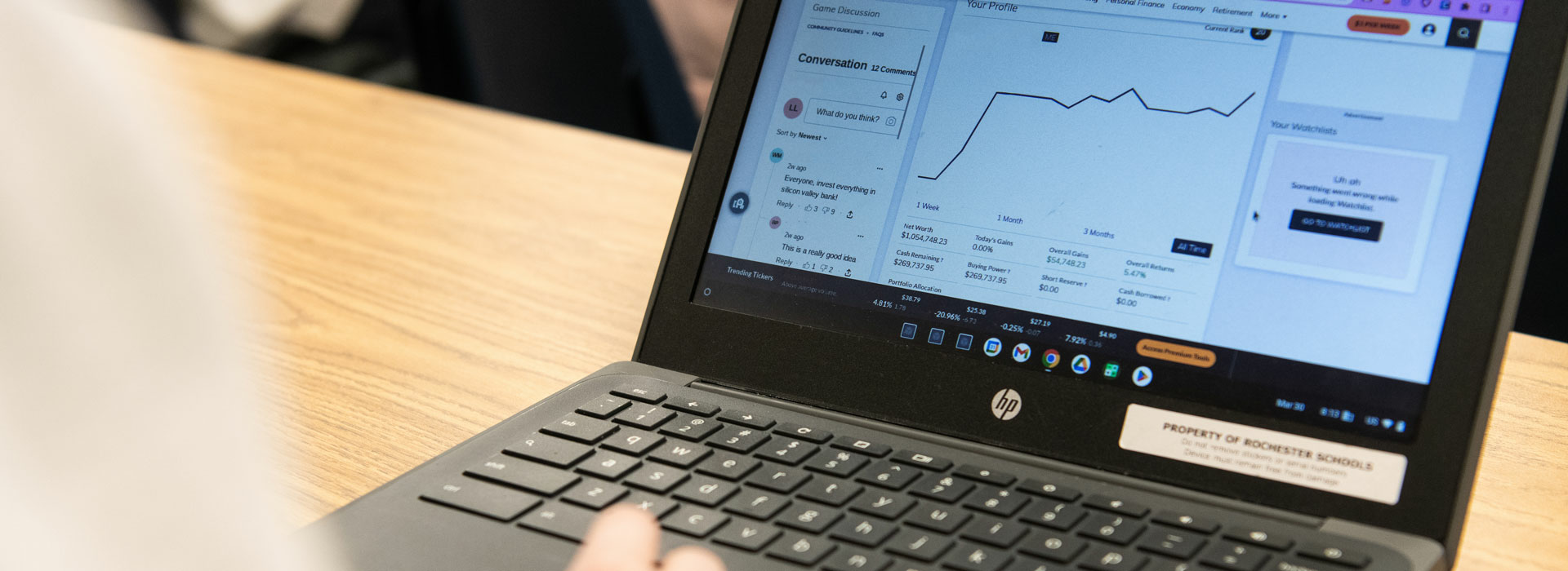 a student at a laptop looking at the stock market