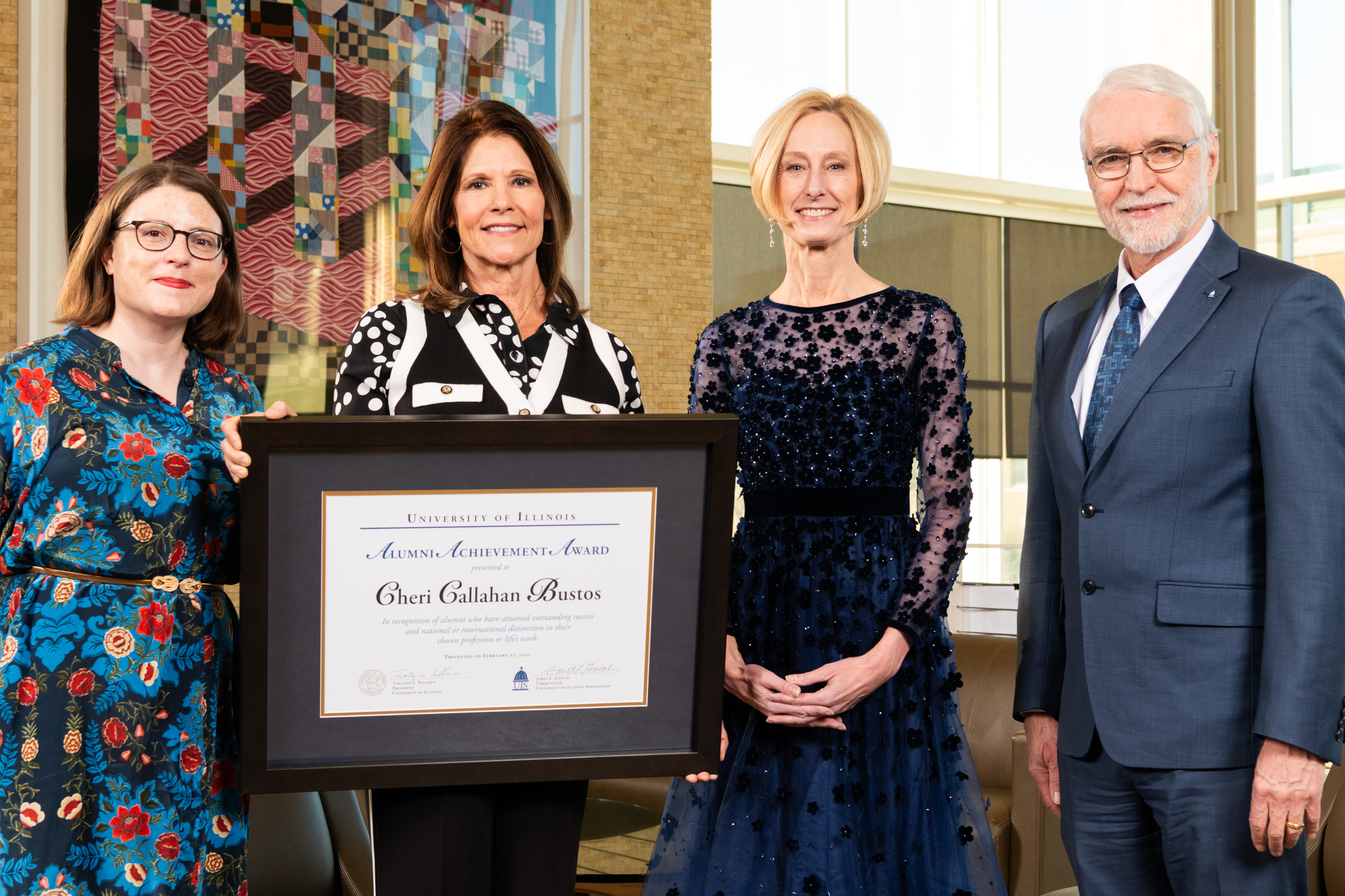 Carly Hawkins, Chancellor Janet Gooch, President Tim Killeen pose with Alumni Achievement award winner Cheri Bustos