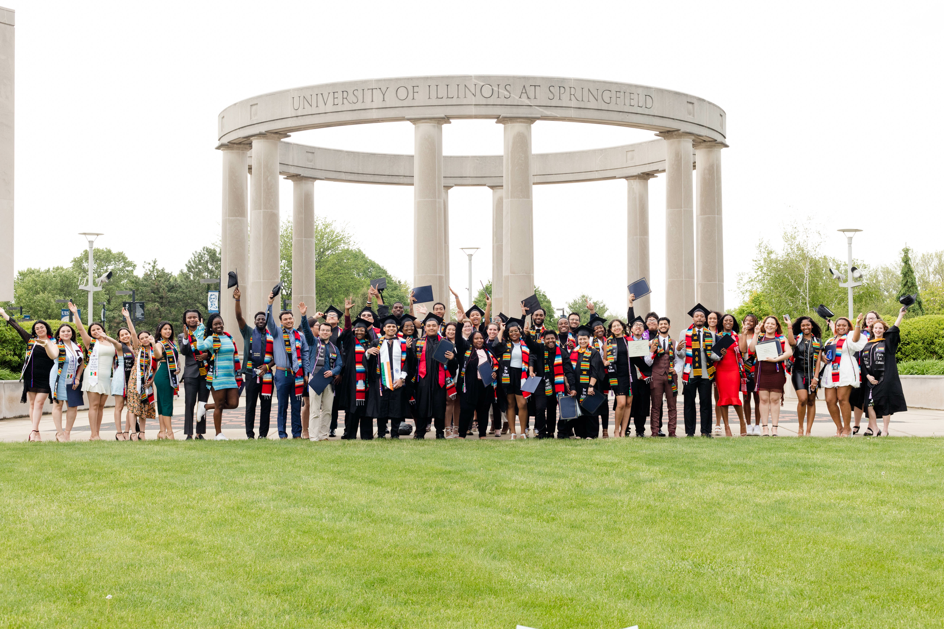 Recent graduates in front of the UIS Colonnade