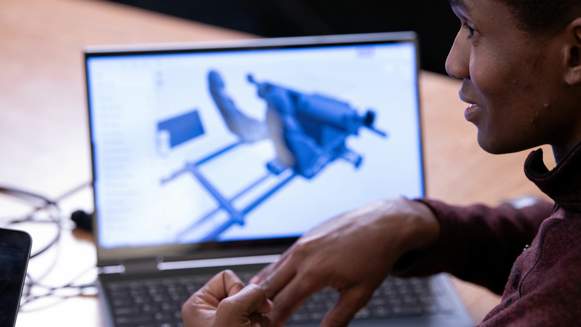 a person at their laptop with a computer design program up on the screen