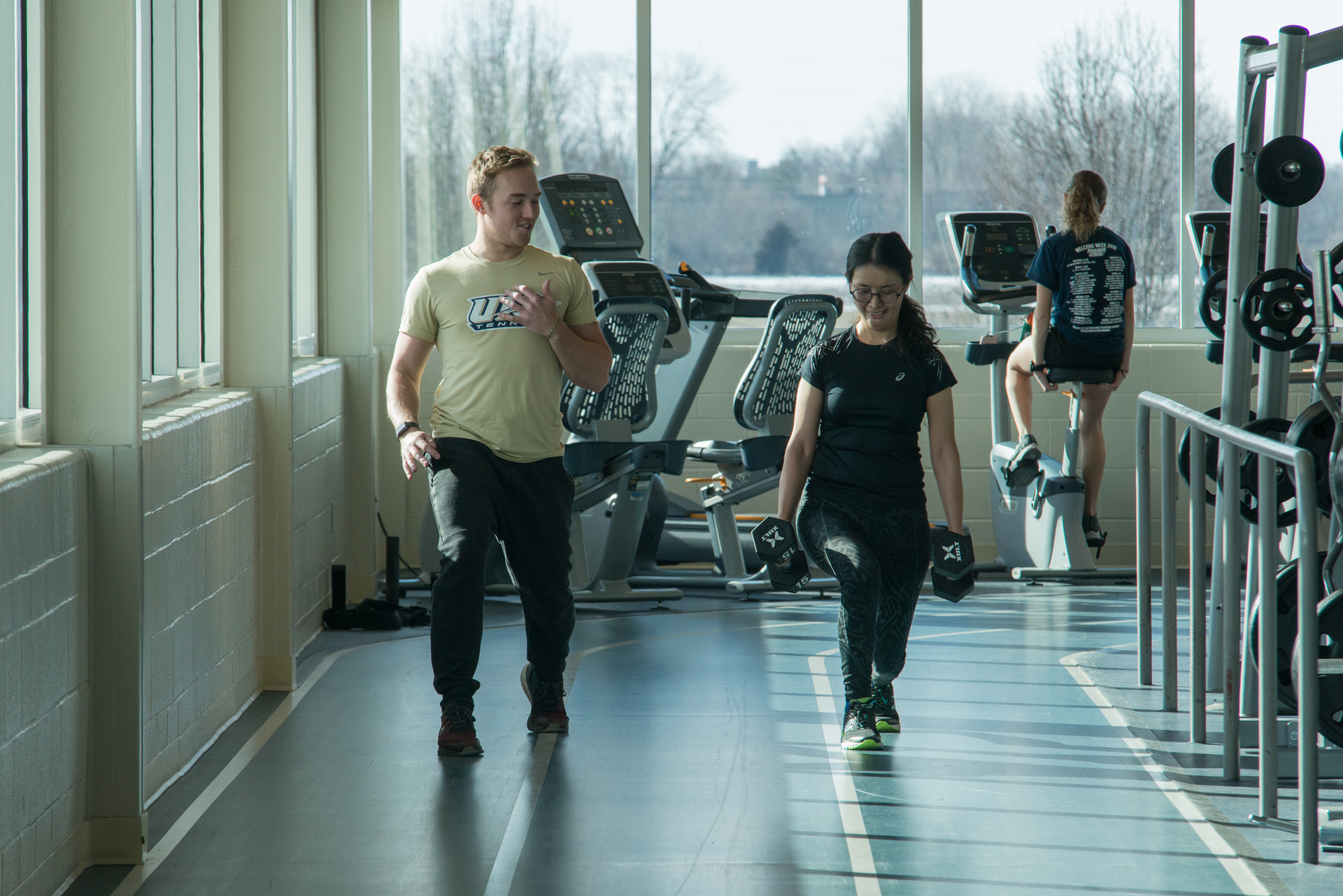 Trainer doing lunges on the track with student client