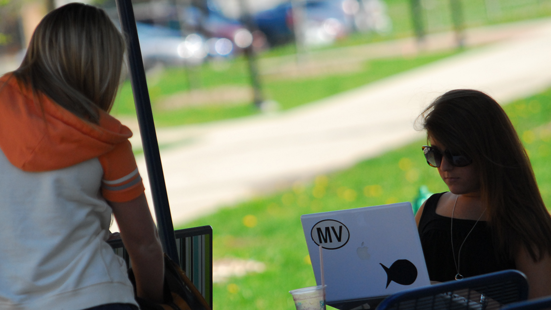 2 people working on computers outside