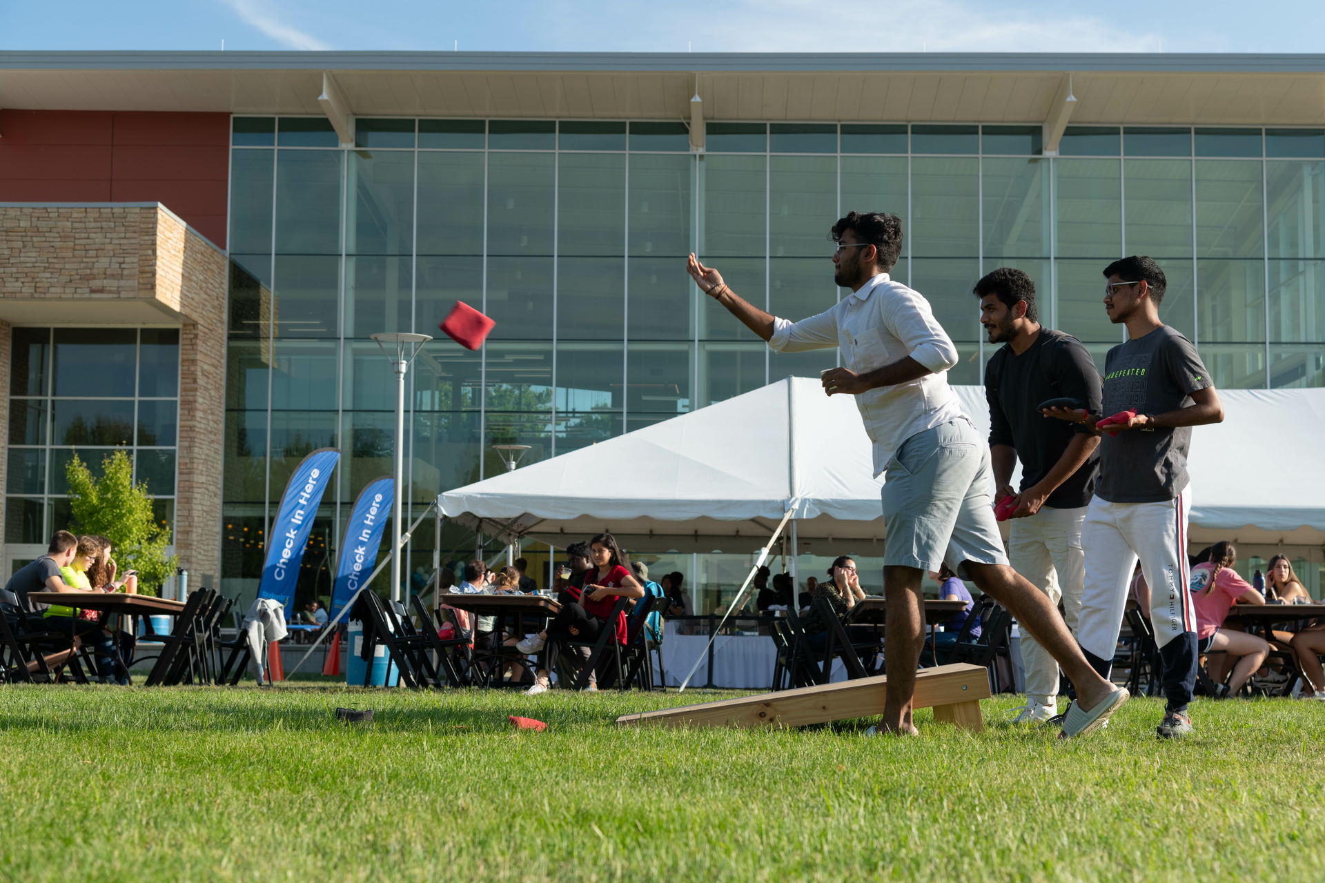Student playing cornhole in front of the Student Union.