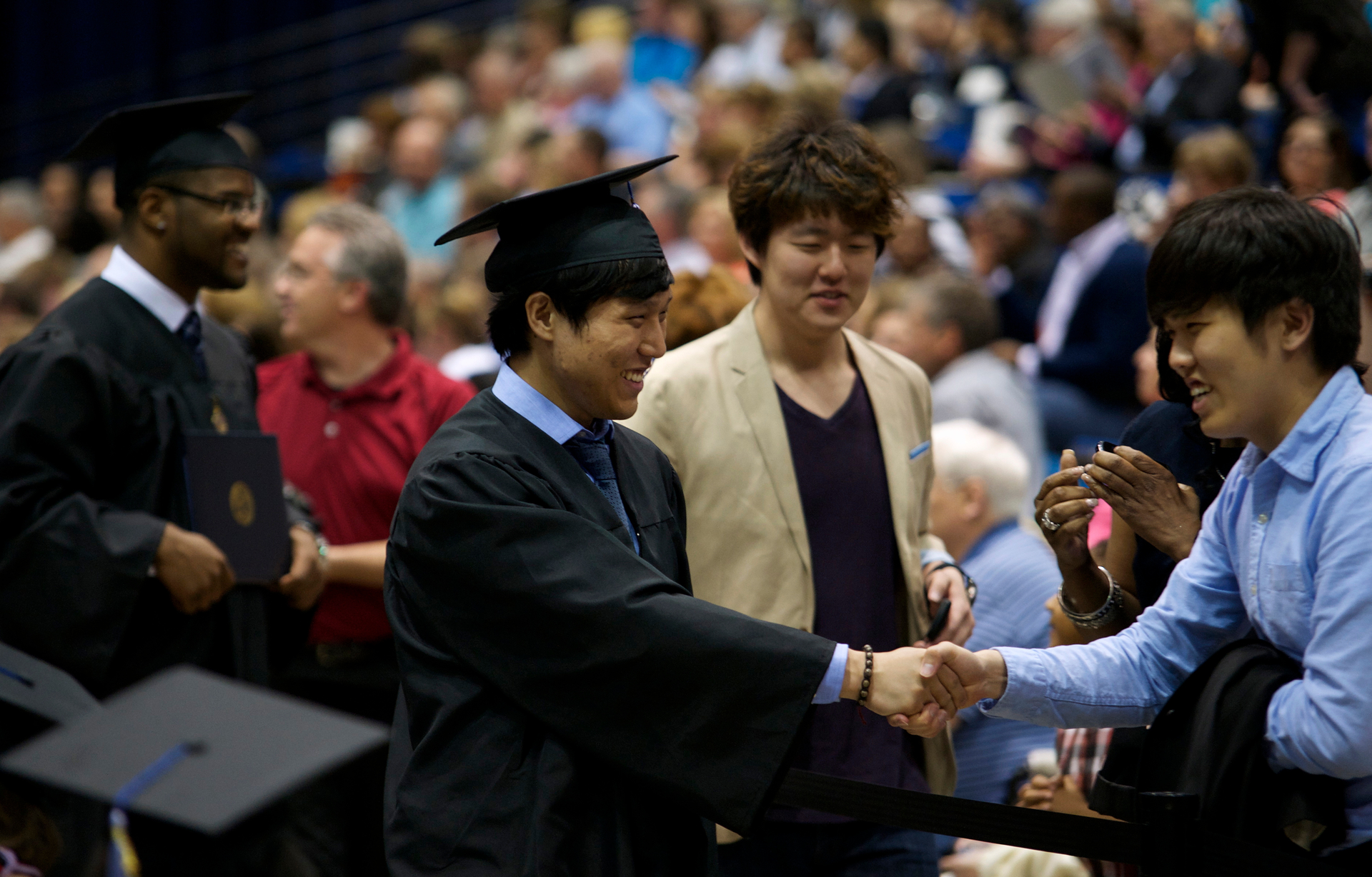 Two people shake hands at a UIS commencement ceremony