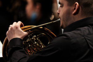 Musician playing a French horn.